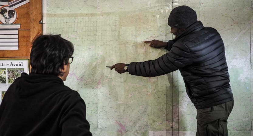a person points at a map while another looks on during an outward bound gap year course